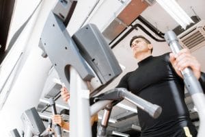 male working out on an elliptical trainer- Fitnessexpostores