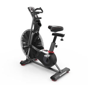 A stationary exercise bike with a seat on a white background