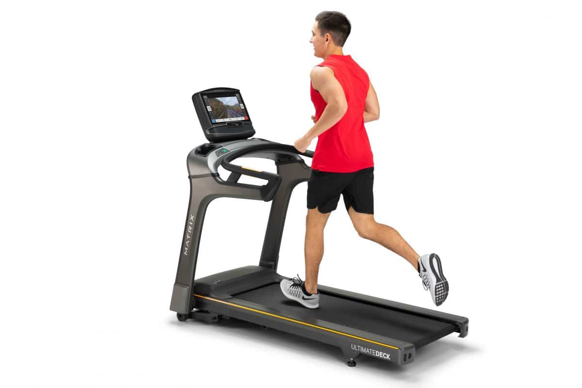 A man is running on a tread machine.