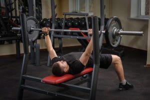 man lifting a barbell in a training bench - Fitness Expo