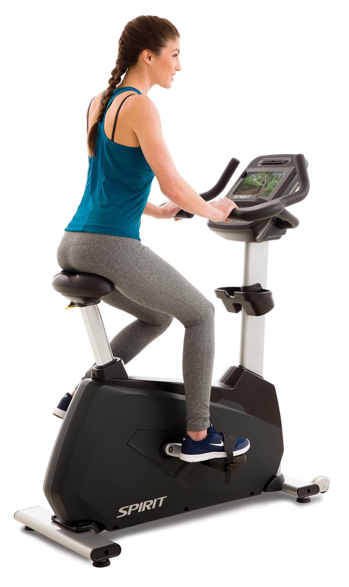 A woman riding an exercise bike on a white background.