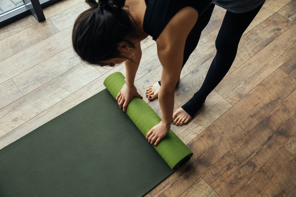 girl putting yoga mat on floor - Fitness Expo