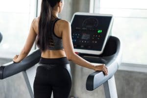 Woman walk and run on treadmills in gym - Fitness Expo