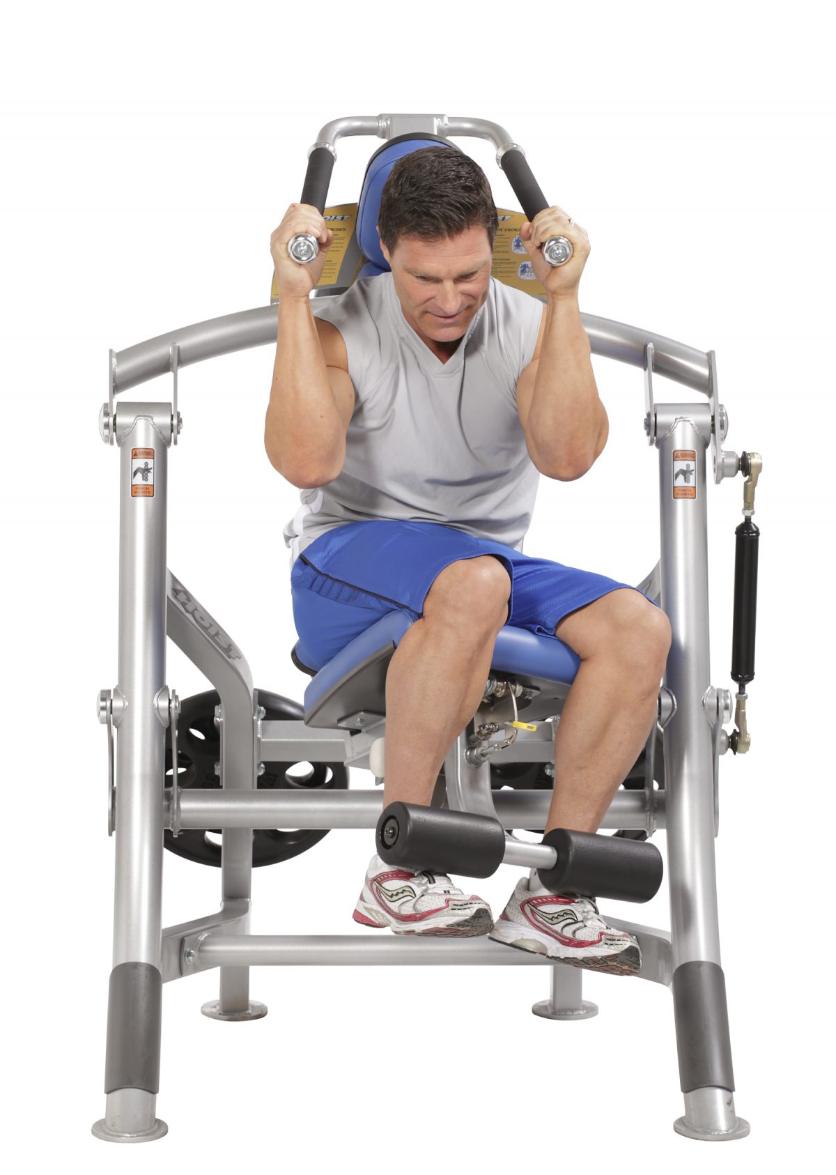 A man is sitting on a machine doing a bicep curl.
